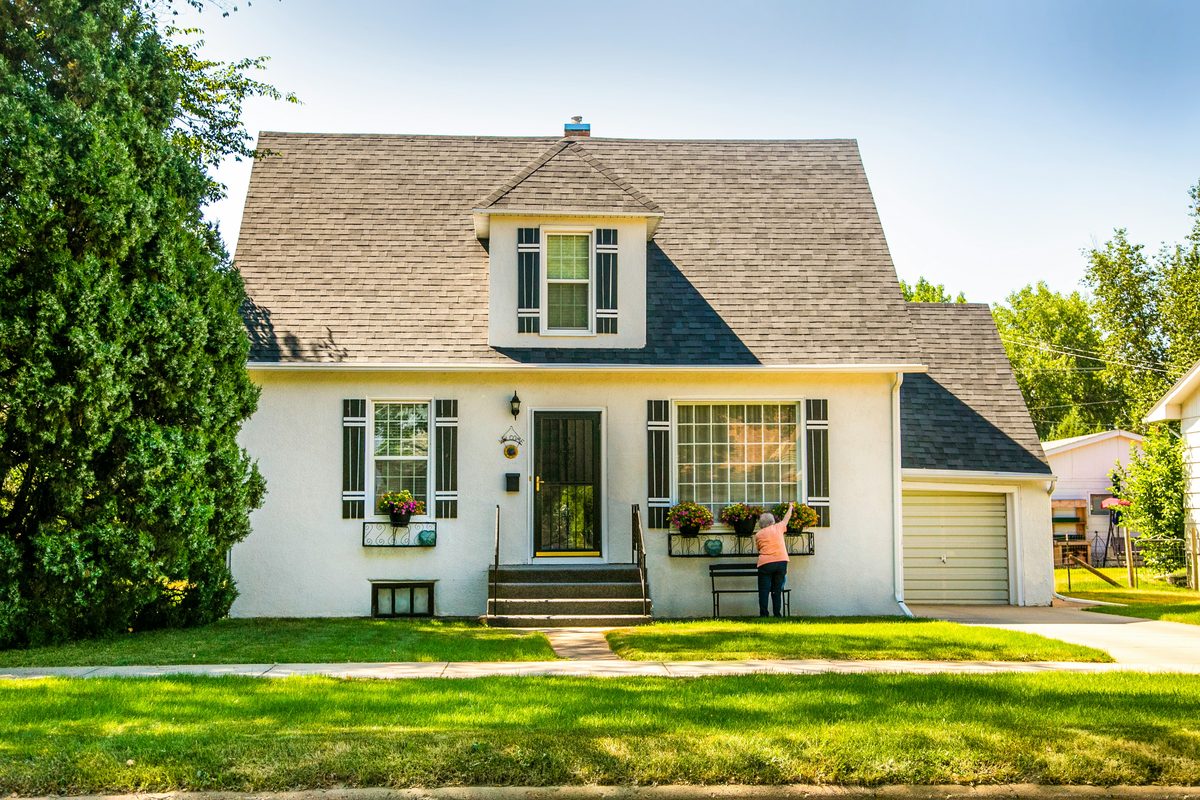 A sunny suburban home with the owner out front